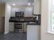 Modern kitchen boasts stainless steel appliances, gray cabinets, and granite countertops at 1380 Ashbrook Dr, Lawrenceville, GA 30043
