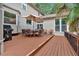 A multi-level wooden deck, features an umbrella table set and a grill, with views of the lush backyard at 3656 Ebenezer Rd, Marietta, GA 30066