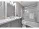 Bathroom featuring gray vanity with marble countertop and tiled bathtub with sliding glass doors at 3656 Ebenezer Rd, Marietta, GA 30066