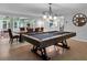 Billiards table under a chandelier beside a dining table and chairs set in a game room at 3656 Ebenezer Rd, Marietta, GA 30066