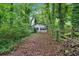 Detached garage surrounded by overgrown plants, trees and wooden fence at 3656 Ebenezer Rd, Marietta, GA 30066