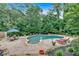 Beautiful kidney-shaped pool surrounded by lush landscaping, patio furniture, and rock accents at 3656 Ebenezer Rd, Marietta, GA 30066