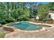 In-ground pool featuring a hot tub, sunbathing area, and lush landscaping, creating a tranquil backyard retreat at 3656 Ebenezer Rd, Marietta, GA 30066