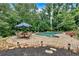 Swimming pool area surrounded by lush trees, an outdoor dining set, and lounge chairs at 3656 Ebenezer Rd, Marietta, GA 30066
