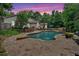 Enjoy the evening in this private pool and backyard featuring lush landscaping under a colorful sunset sky at 3656 Ebenezer Rd, Marietta, GA 30066