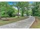 Scenic view of a well-maintained home and driveway, surrounded by mature trees and landscaping at 3656 Ebenezer Rd, Marietta, GA 30066
