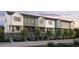 Beautiful modern townhome complex with multiple units, white siding and black window accents, set amongst green trees at 434 Argosy Park Cir # 13, Alpharetta, GA 30005