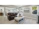 Cozy living room with a brown leather couch, light hardwood floors, and lots of natural light at 4824 Dunwoody Station Dr, Atlanta, GA 30338