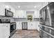 Modern kitchen featuring stainless steel appliances, white cabinets, granite countertops, and new flooring at 2089 Christian Se Cir, Conyers, GA 30013