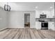 Open kitchen with stainless appliances, grey backsplash, white cabinetry, and modern flooring at 2089 Christian Se Cir, Conyers, GA 30013