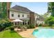 Beautiful backyard with a pool, patio seating, lush landscaping, and classic home architecture at 2878 Wesley Heath Nw, Atlanta, GA 30327