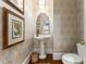 Charming powder room featuring decorative wallpaper, a pedestal sink, and framed artwork, creating a stylish and functional space at 2878 Wesley Heath Nw, Atlanta, GA 30327