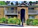Inviting condo exterior with brick archway, white railings, and lush landscaping at 3120 Seven Pines Court # 203, Atlanta, GA 30339