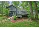 The back exterior of the house features a deck, green lawn, screened porch, and mature trees at 588 Benson Hurst Dr, Mableton, GA 30126