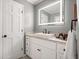 Bathroom featuring white cabinets, granite countertops, and a stylish LED mirror at 588 Benson Hurst Dr, Mableton, GA 30126
