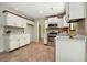 Traditional kitchen boasts white cabinets, stainless steel appliances, and tile backsplash adding a touch of charm at 588 Benson Hurst Dr, Mableton, GA 30126