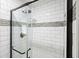 Close-up of a tiled shower featuring white subway tiles and a glass door at 588 Benson Hurst Dr, Mableton, GA 30126