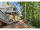 Multi-level deck overlooking the backyard with steps to the lawn and wooded surroundings at 7235 Compton Cir, Cumming, GA 30040