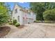 Side view of home with two-car garage, American flag, paved driveway, and lush landscaping at 7235 Compton Cir, Cumming, GA 30040