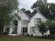 Charming two-story home with painted brick, arched entry, manicured lawn and mature trees at 7235 Compton Cir, Cumming, GA 30040