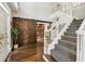 Grand foyer with hardwood floors, staircase, and sliding barn door to an office with built-in bookshelves at 7235 Compton Cir, Cumming, GA 30040
