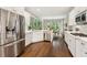 Eat-in kitchen showcasing stainless steel appliances, white cabinetry, and a view to the outside dining area at 7235 Compton Cir, Cumming, GA 30040