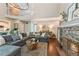 Open-concept living area with stone fireplace, vaulted ceilings, and a view into the kitchen and entry at 7235 Compton Cir, Cumming, GA 30040