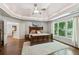 Spacious main bedroom with hardwood floors, tray ceiling, large windows, and access to the main bathroom at 7235 Compton Cir, Cumming, GA 30040