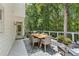 Outdoor patio area features a dining table, chairs, and a view of the surrounding greenery at 7235 Compton Cir, Cumming, GA 30040