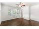 Bedroom with hardwood floors, ceiling fan, large window, and door to hallway at 115 Biscayne Nw Dr # F1, Atlanta, GA 30309