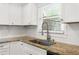 Well-lit kitchen featuring granite countertops, white cabinetry, and a stainless steel faucet at 115 Biscayne Nw Dr # F1, Atlanta, GA 30309