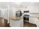 Open kitchen with stainless steel appliances, a granite island, and hardwood flooring at 115 Biscayne Nw Dr # F1, Atlanta, GA 30309