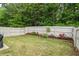 Well-maintained backyard with green grass, manicured flower beds, and a privacy fence at 2860 Cooper Brook Dr, Snellville, GA 30078