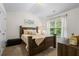 Cozy bedroom featuring a comfortable bed, dresser, and a window with natural light at 2860 Cooper Brook Dr, Snellville, GA 30078