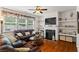 Inviting living room featuring a fireplace, built-in shelving, hardwood floors, and a leather sofa at 2860 Cooper Brook Dr, Snellville, GA 30078
