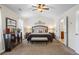 Spacious main bedroom featuring a ceiling fan, en-suite bathroom, and bench at the foot of the bed at 2860 Cooper Brook Dr, Snellville, GA 30078