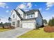 Elegant home with a two-car garage, showcasing a combination of stone and white siding with a well kept lawn at 4480 Beechnut Cir, Cumming, GA 30028