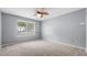 Neutral bedroom with carpeted floor, ceiling fan, large window with blinds, and built-in shelves at 47 Arbor End, Smyrna, GA 30080