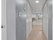 Hallway leading to kitchen features wood floor, closet, and view into kitchen with white cabinets at 47 Arbor End, Smyrna, GA 30080