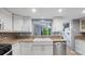 Modern kitchen with white cabinets, mosaic backsplash, granite countertops, and stainless appliances at 47 Arbor End, Smyrna, GA 30080