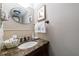 Elegant powder room featuring an oval mirror, marble countertop, and decorative tile backsplash at 2260 Peachtree Nw Rd # B4, Atlanta, GA 30309