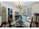 Bright dining room with a glass-top table, chandelier, plantation shutters, and access to pantry at 2260 Peachtree Nw Rd # B4, Atlanta, GA 30309