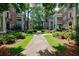 Beautiful brick townhomes with manicured landscaping, lush green trees, and a concrete walking path at 2260 Peachtree Nw Rd # B4, Atlanta, GA 30309