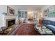 Sunlit living room boasts a fireplace, hardwood floors, stylish decor, and built-in bookshelves at 2260 Peachtree Nw Rd # B4, Atlanta, GA 30309