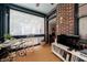 Inviting sunroom with brick wall, television, and quaint table setting for relaxation and entertainment at 2260 Peachtree Nw Rd # B4, Atlanta, GA 30309