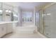 A luxurious bathroom boasts tile floors, dual sink vanity, soaking tub, and glass shower at 2883 Thurleston Ln, Duluth, GA 30097
