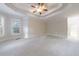 Open bedroom with neutral carpet, a tray ceiling, and lots of natural light from the many large windows at 2883 Thurleston Ln, Duluth, GA 30097