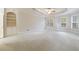 A spacious, carpeted main bedroom featuring a tray ceiling, built-in shelving, and large windows at 2883 Thurleston Ln, Duluth, GA 30097