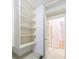 A walk-in closet boasts custom built-ins with multiple open shelves, next to a door and hallway at 2883 Thurleston Ln, Duluth, GA 30097