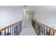 Hallway with wood and wrought iron railing and neutral carpeting at 2883 Thurleston Ln, Duluth, GA 30097